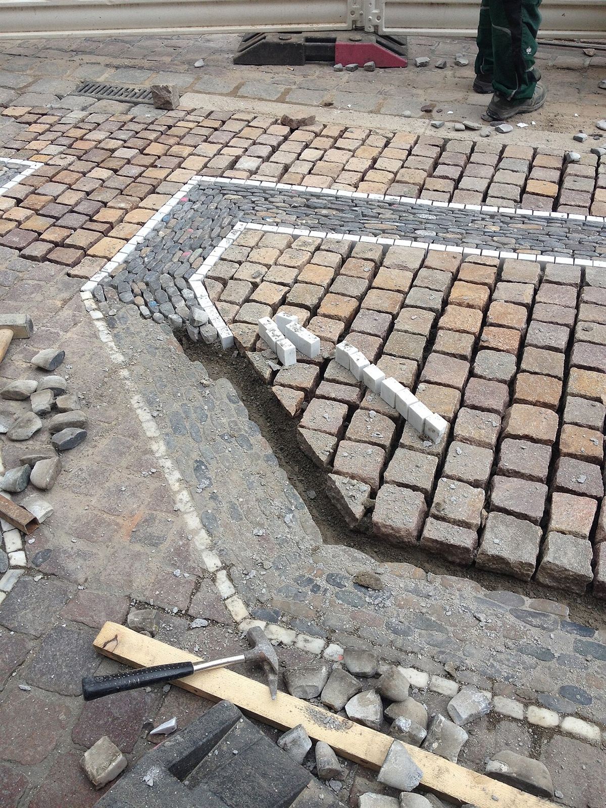 A landscaper laying sett block paving for a new patio