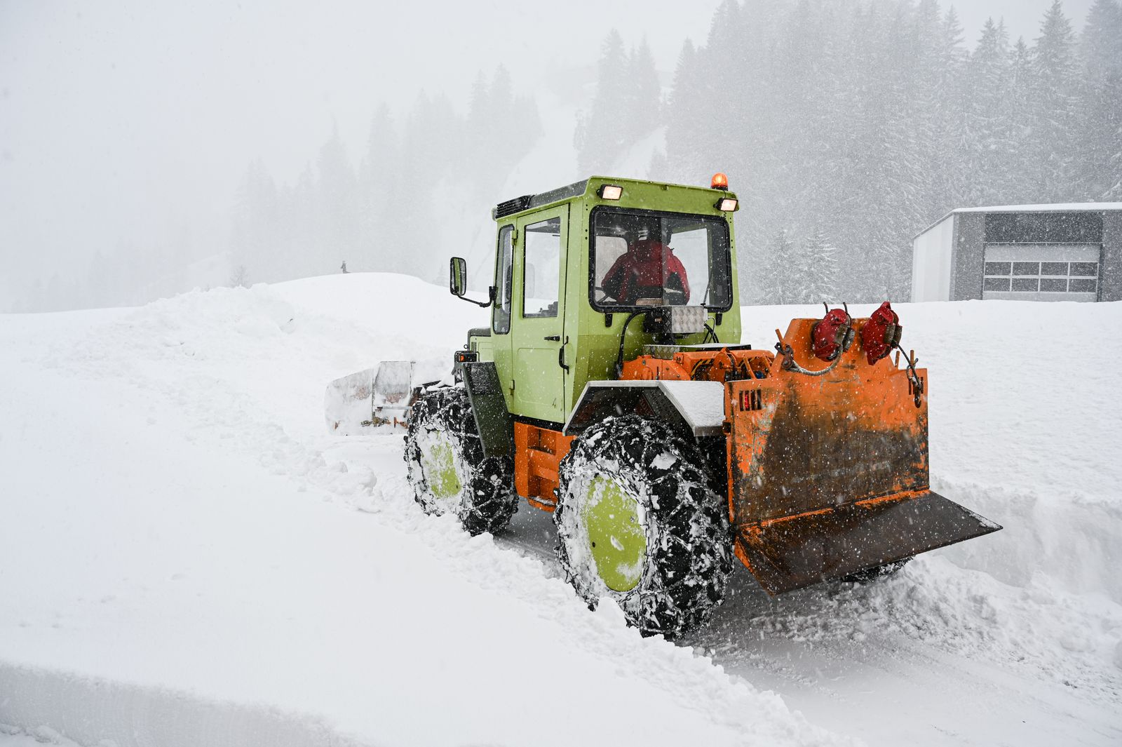 Snow plow clearing heavy snow during a storm